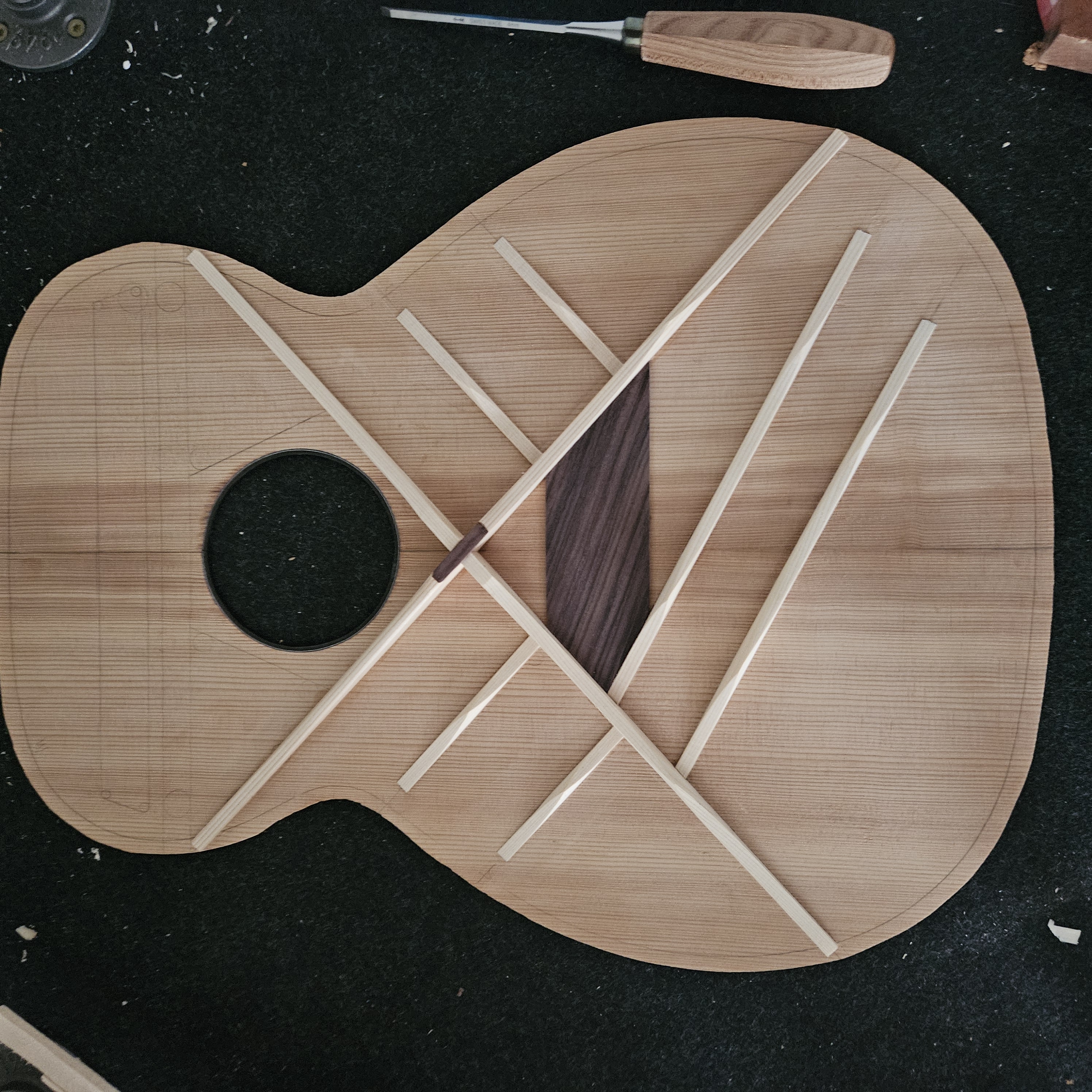 Guitar top with bracing pattern and walnut bridge plate laid out before assembly
